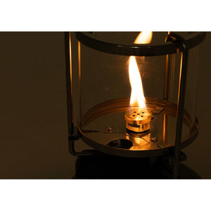 Lit gas lantern with glass casing and metal frame