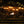 People sitting in Snow Peak folding chairs around a fire pit on a stone patio at night
