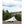 Snow Peak tent set up in a field with trees and hills in the background