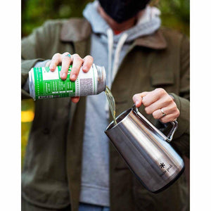 Person pouring beer from a can into a stainless steel Snow Peak mug