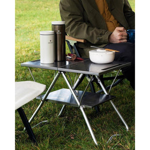 Snow Peak metal camping table with two tumblers and a bowl on top