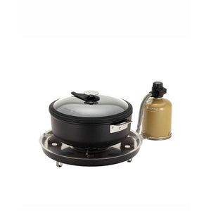 Snow Peak camping stove with a black cooking pot and glass lid attached to a fuel canister