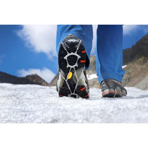 Person wearing crampons on hiking boots walking on snow