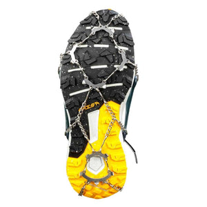Snowline traction spikes attached to the sole of a hiking shoe