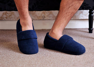 Person wearing navy blue SnugToes fleece slippers