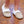 Child wearing tan suede slippers with white faux fur trim on a wooden floor