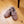 Pair of mauve faux fur lined slippers on a wooden floor