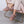 Person wearing mauve faux fur lined suede slippers while sitting in a pink velvet chair