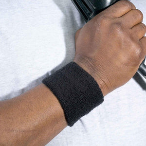 Person wearing a black terry cloth wristband while holding a gym weight