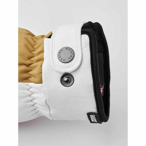 Hestra glove cuff detail with white leather strap and branded metal snap buttons