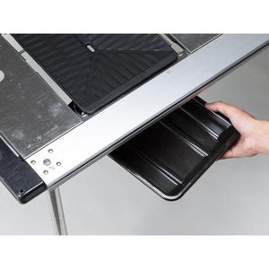 Hand sliding a black tray into a Snow Peak metal camping table