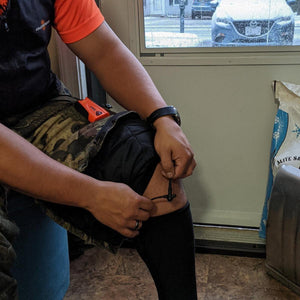 Person connecting power cable to California Heat heated pants