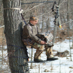 Hunter in tree stand holding a Heater Body Suit