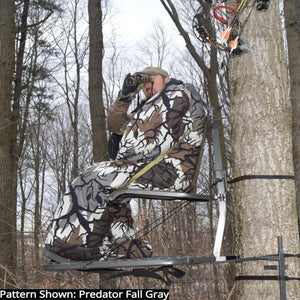 Hunter in a Heater Body Suit using binoculars in a tree stand