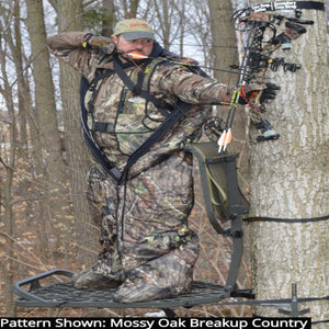 Hunter wearing a Heater Body Suit in Mossy Oak Breakup Country camo pattern while aiming a compound bow in a tree stand