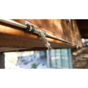 The Patio Misting System nozzle mounted on a wooden beam spraying a fine mist