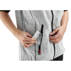 Person placing a Therm-ic heat pack into the zippered pocket of a grey heathered fleece vest