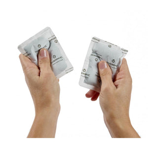 Hands holding two Therm-ic branded heat packs