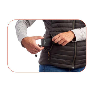 Person placing a Therm-ic battery pack into the pocket of a black quilted vest
