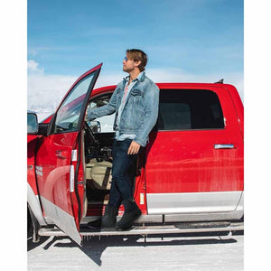 Man wearing ThermalStep boots standing by a red truck in a snowy landscape