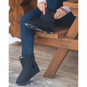 Person wearing black quilted ThermalStep boots while sitting on a wooden bench
