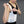 Person adjusting the strap of a white ThermApparel cooling vest over a black top
