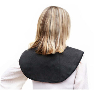 Person wearing a black shoulder heating pad over a white shirt