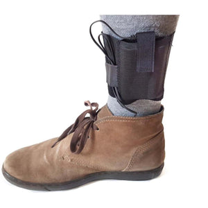 Black ankle strap with wire worn over a grey sock and brown suede shoe