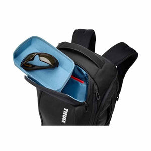 Thule backpack with open top compartment containing sunglasses in a protective case