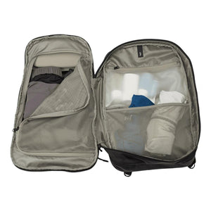 Open Thule travel backpack with internal mesh storage compartments containing clothing and toiletries