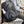 Black backpack with a metal water bottle in the side pocket resting on a wooden bench