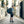 Person wearing a black Thule travel backpack while walking down a narrow city street