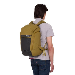 Person wearing a Thule olive green and black backpack from the back