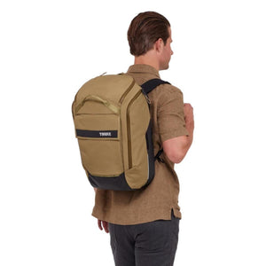Person wearing a tan Thule backpack viewed from the back