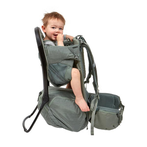Toddler sitting in a green Thule child carrier backpack