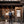 Person wearing a Thule backpack standing next to a folding bicycle in front of a wooden storefront