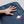 Hand resting on a black ToastiMat surface with a flame logo