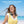 Woman wearing a portable neck fan on a beach