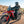 Motorcyclist wearing Tourmaster gear riding a red dual sport motorcycle on a dirt road