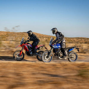Two motorcyclists wearing Tourmaster gear riding dual sport motorcycles on a dirt path