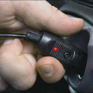Trillium Worldwide power adapter with red indicator light plugged into a vehicle outlet