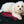 Small white dog lying on a Trillium Worldwide red plaid electric heating pad