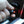 Hand inserting a car charger adapter into a vehicle power outlet with a glowing red indicator light
