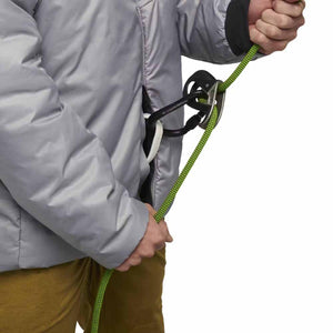 Person wearing a Black Diamond jacket using a belay device with a green climbing rope