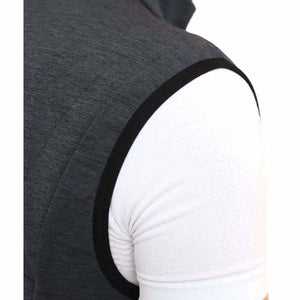 Close up of dark grey quilted vest shoulder with black trim over white t-shirt