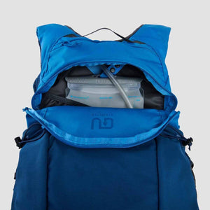 Ultimate Direction blue hydration backpack with open compartment showing water reservoir