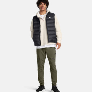 Model wearing Under Armour black puffer vest over cream zip jacket and olive green joggers