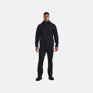Man wearing black Under Armour hooded jacket and black trousers