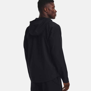 Man wearing a black Under Armour hooded jacket seen from the back
