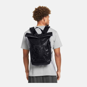 Person wearing a black Under Armour roll top backpack with bungee cord detail